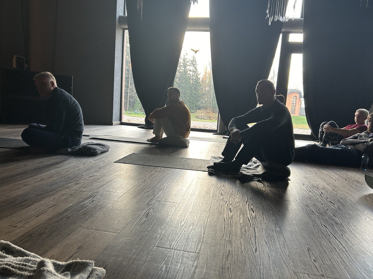 Meditators silhouetted against windows